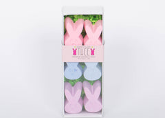 Box of TWEE six piece children's bunny shaped pink, blue, and purple chalk. White background.