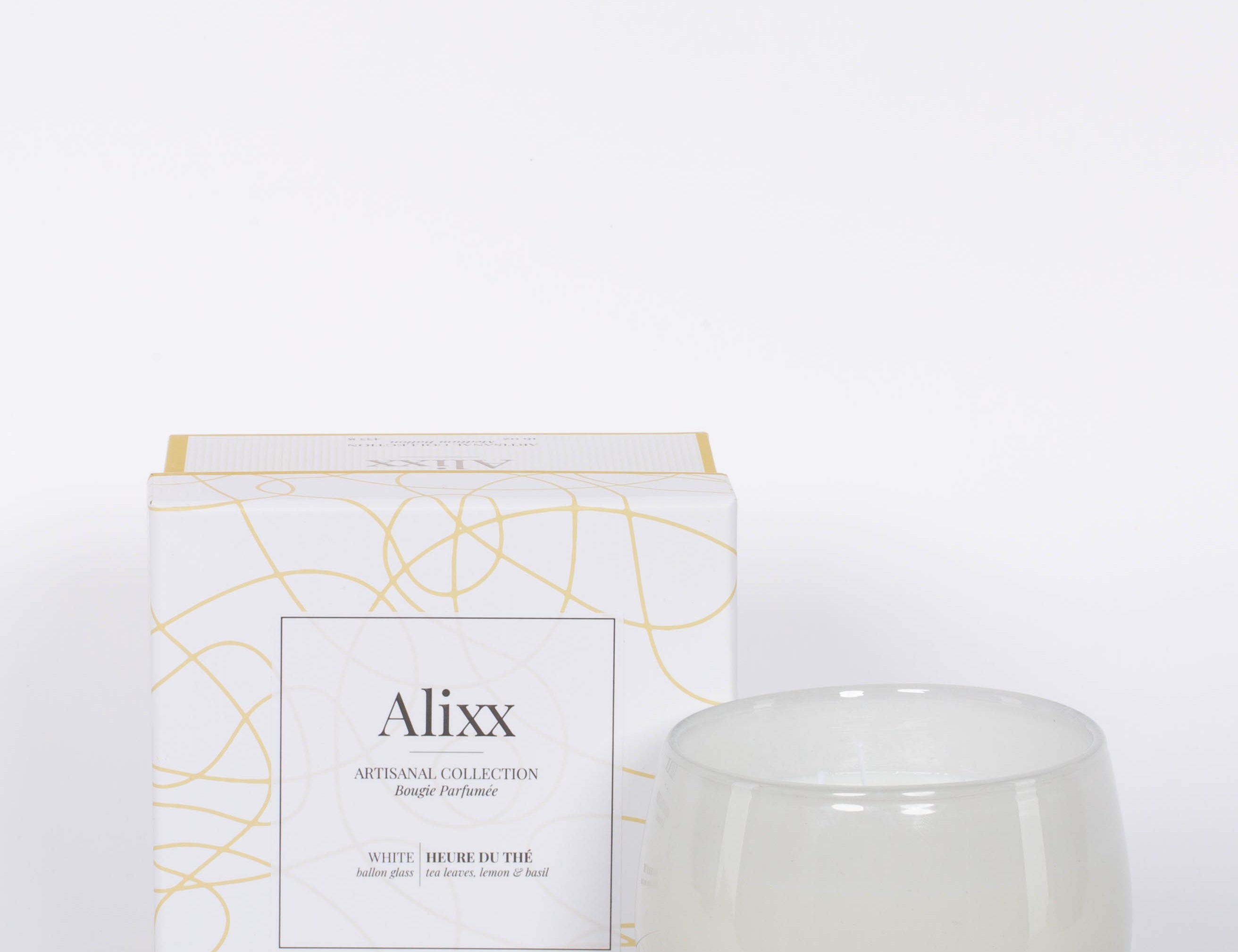 16oz Heure du Thé Ballon candle by Alixx in white with white and gold pattern box. Lily of the valley, water cedar, and musk fragrance. White background.