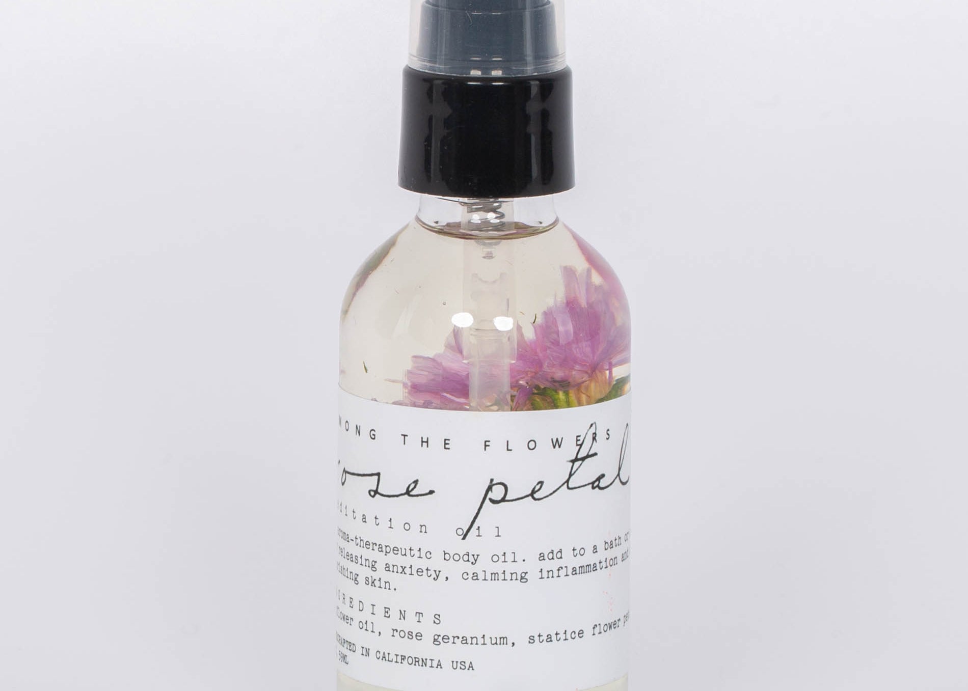 Rose Petal Body Oil by Among the Flowers in clear spray bottle white label. 